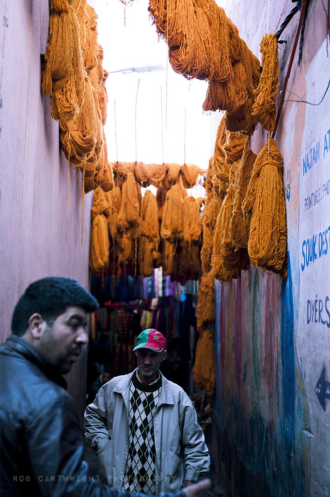 marrakesh maroc morocco africa street market souks dyers colours wool fabric men candid vivid orange pigment 50mm rob cartwright
