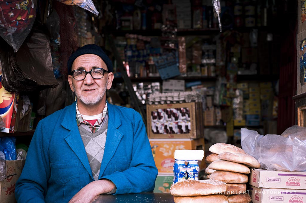 marrakesh maroc morocco north africa street urban market trader portrait blue jacket glasses hat shop 50mm rob cartwright